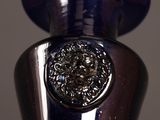 a blue vase that has a silver decoration on it