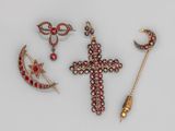 trois bijoux, dont une croix, un croissant et une broche en forme de croissant