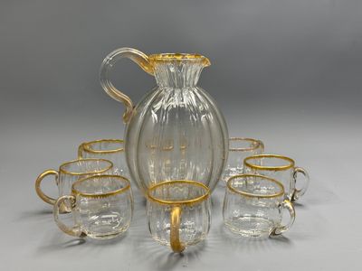 une image représentant un pichet en verre et six verres posés sur une table
