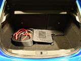 the trunk of a blue car with a bunch of wires in it