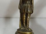 brass figurines of a soldier and a soldier on a pedestal