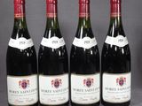 quatre bouteilles de vin sont alignées sur une table