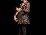 an old wooden statue of a man with a hat and coat