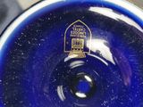 a blue glass vase that has a label on it
