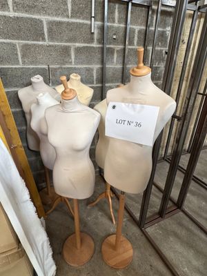 trois mannequins exposés, assis dans une pièce