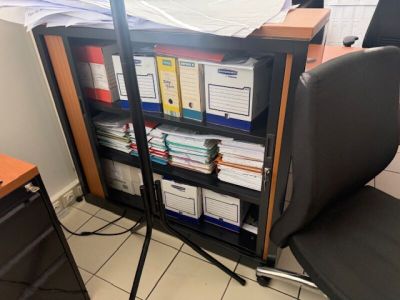 a black chair sitting in front of a book case