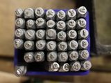a bunch of metal stamps sitting in a blue container