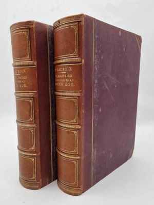 two old books sitting on top of each other on a white surface