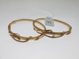 paire de bracelets rigides de couleur dorée, ornés de pierres transparentes de chaque côté