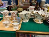 une table verte sur laquelle sont disposés de nombreux vases anciens
