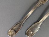 two silver spoons and a fork on a gray surface