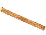 gros plan d'un bracelet en or sur fond blanc