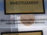 a gold coin on display in a glass case