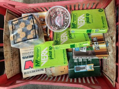 a red basket filled with assorted items on the ground
