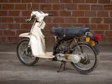 a motor scooter that is parked in front of a brick wall