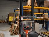 a fork lift truck in a warehouse with pallets in the background