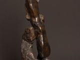 a bronze statue of a man holding a dog on top of a wooden table
