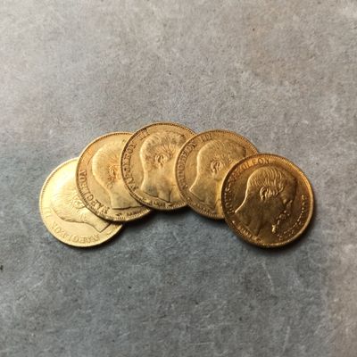 cinq pièces d'or empilées les unes sur les autres sur une table