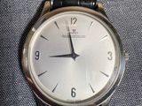 une montre en argent avec un bracelet en cuir noir