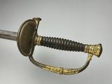 a close up of a sword on a white surface