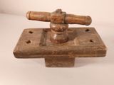 a small wooden object with a wooden handle on it
