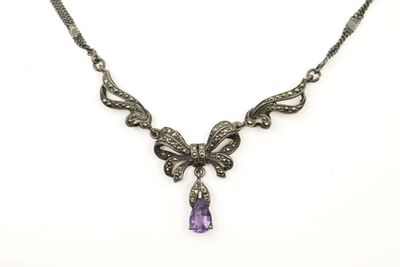 un collier orné d'un améthyste et d'une pierre violette