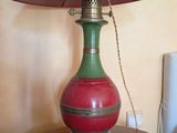 une lampe rouge et verte posée sur une table, avec un parapluie rose