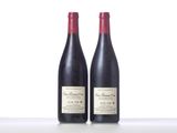 two bottles of red wine sitting on top of a table