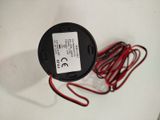 a red wire that is connected to a black and white button