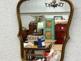 a mirror hanging on a wall with a clock on it