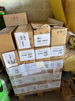 une pile de cartons, les uns sur les autres, posée par terre dans une pièce