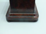 a brown clock sitting on top of a wooden stand