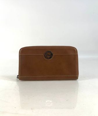 a brown leather wallet with a circular logo on the front