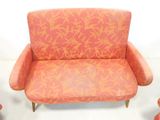 a pink chair with orange flowers on it in a room