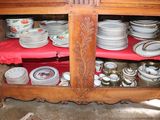 a wooden cabinet with many plates and bowls on it