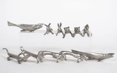 a lot of silver figurines of animals on a white surface