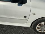 une petite voiture blanche garée sur le bord de la route
