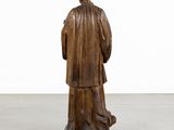 a wooden statue of a man in a robe and hat