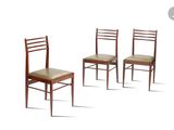 three wooden chairs sitting next to each other on a white surface