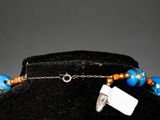 an image of a blue and orange necklace with a tag on it