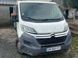 Une camionnette blanche est garée devant un immeuble.