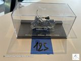une moto miniature dans une vitrine posée sur une table