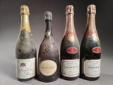 quatre bouteilles de vin sont alignées sur une table