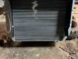 une photo d'un homme tenant un radiateur devant une voiture