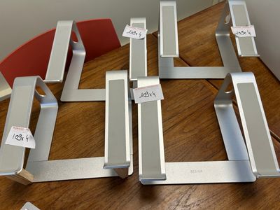 four pieces of metal on a table with tags attached to them