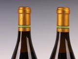 two bottles of wine sitting next to each other on top of a table