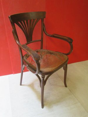 une chaise placée devant un mur rouge