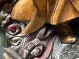a bronze statue of a person riding a dragon