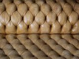 a brown leather couch with buttons on it