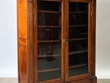 an image of a wooden cabinet with glass doors in a room